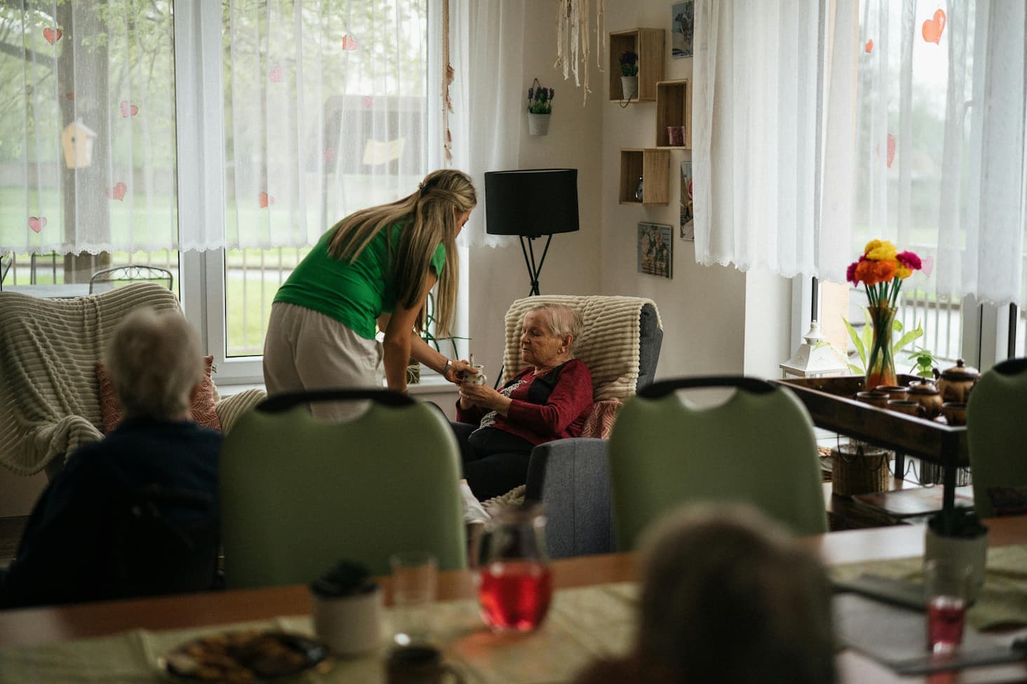 Live-in caregiver serving tea to elderly person a representation of Virginia Agency Directed Care